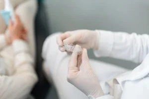 A dentist in Singapore presenting an Invisalign sample to a patient